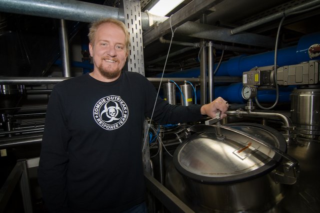 Grady Hull, assistant brewmaster at New Belgium Brewing, proudly displays the company's unique dry hoping dose skid. 