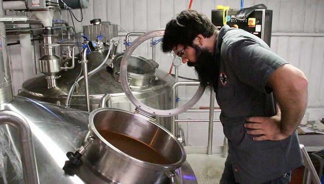 Head brewer Brian Hink looks deep into the soul of a brew kettle at Cape May Brewing Co. 