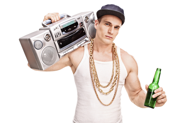Young male rapper carrying a ghetto blaster over his shoulder and holding a bottle of beer isolated on white background