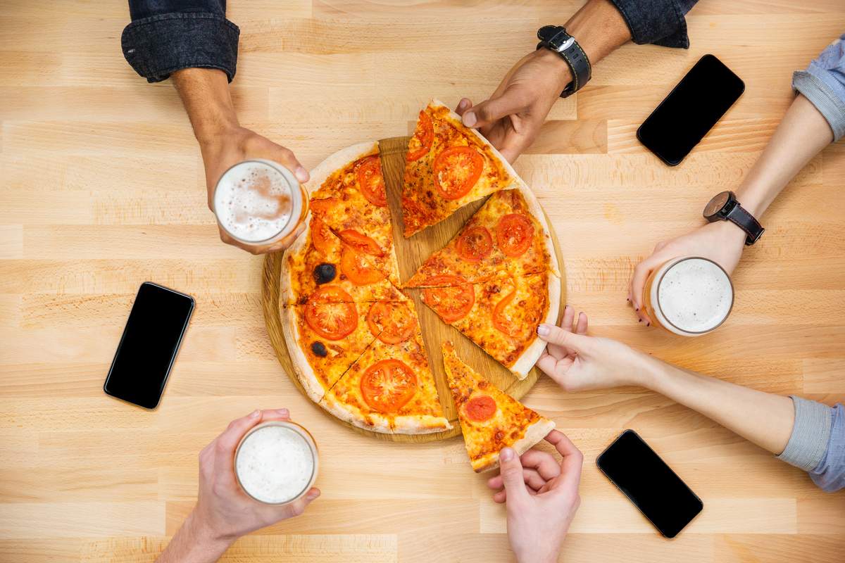 people eating pizza and a beer